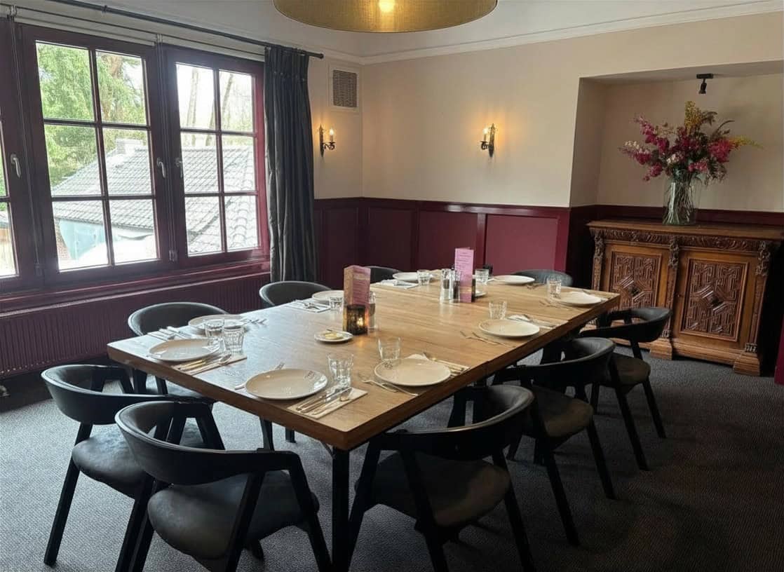 Sfeervolle wijnkamer voor private dining bij De Eetvilla in Soest met lange houten tafel, comfortabele stoelen en warme inrichting